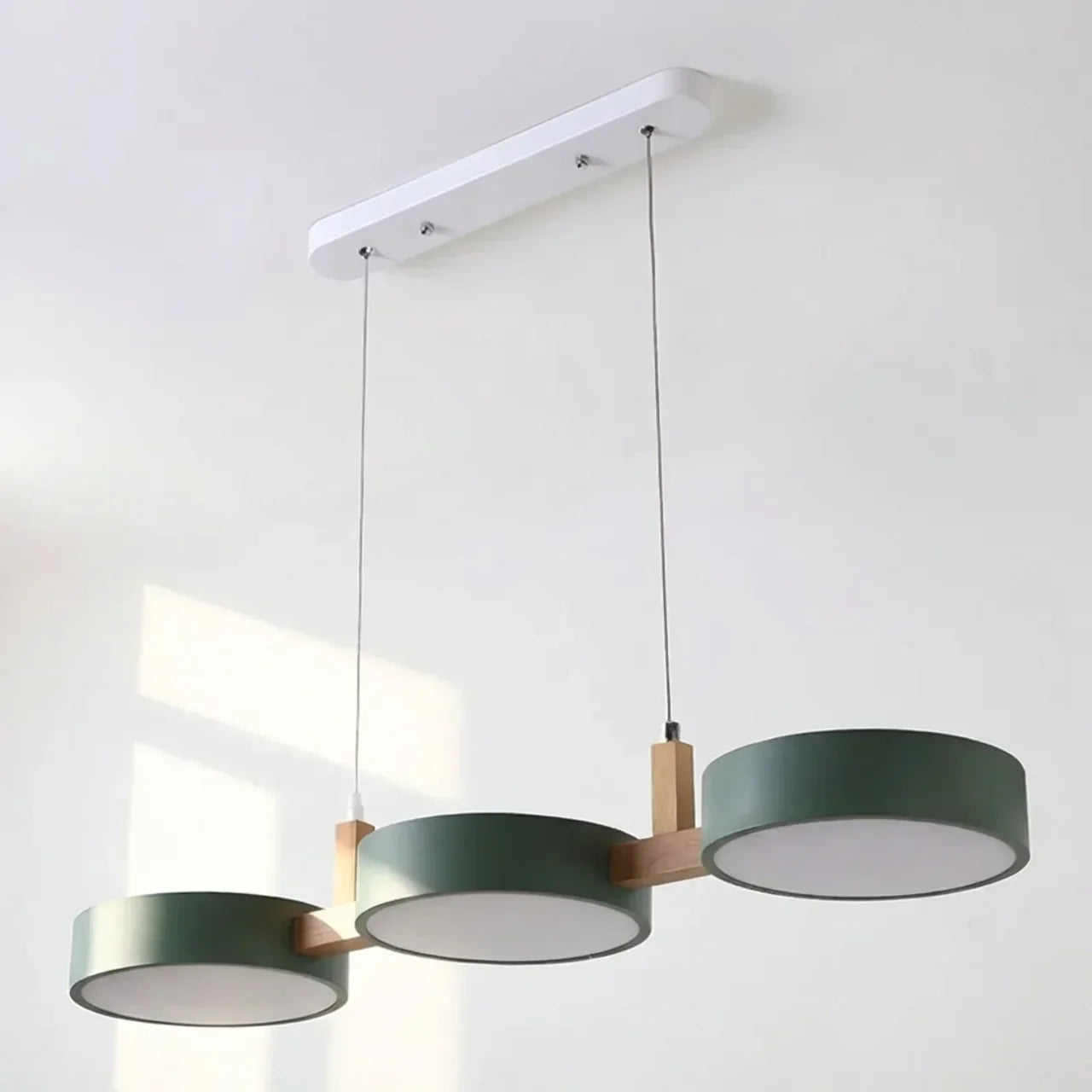 Suspension à poutre en bois avec abat-jours métalliques cylindriques pour îlot de cuisine
