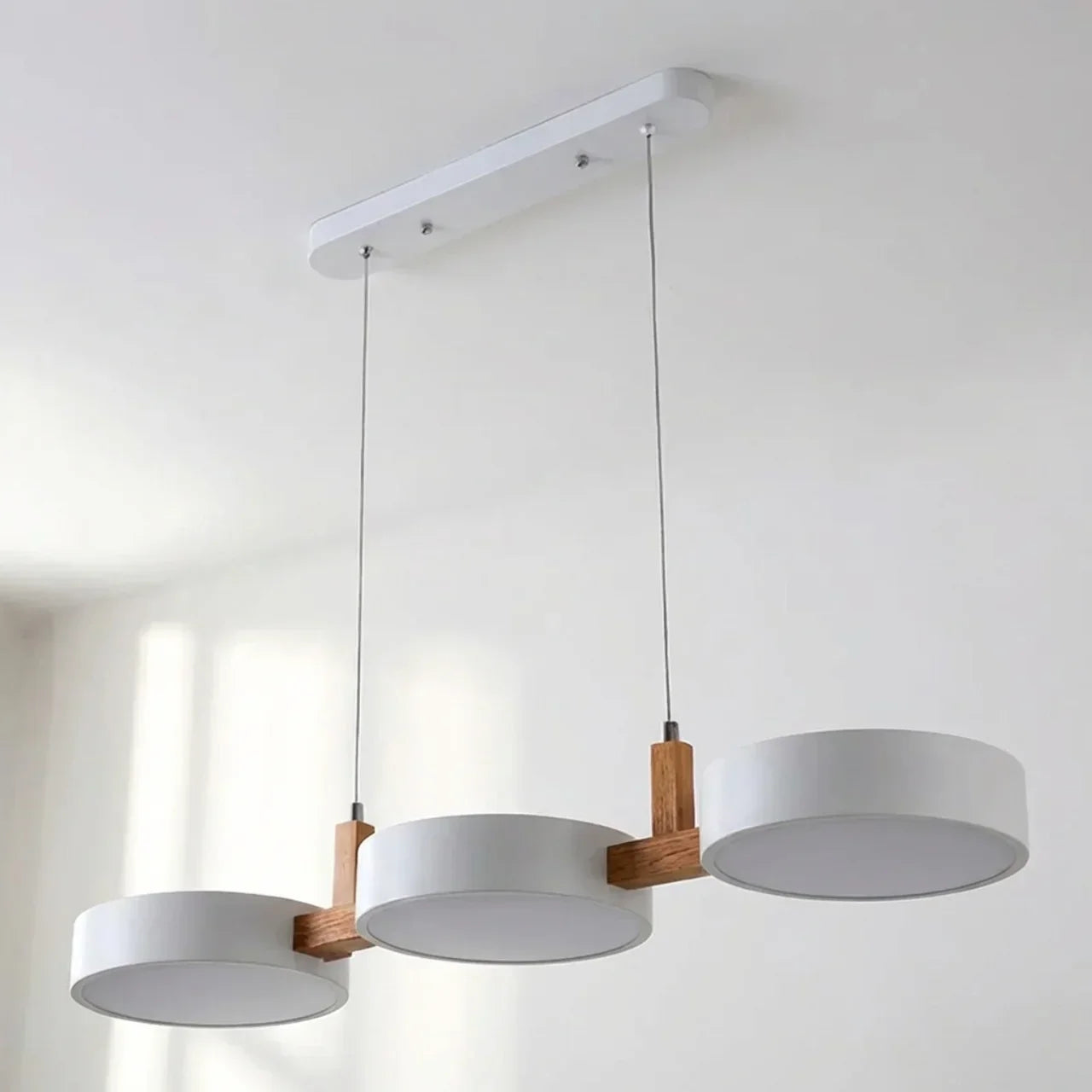 Suspension à poutre en bois avec abat-jours métalliques cylindriques pour îlot de cuisine