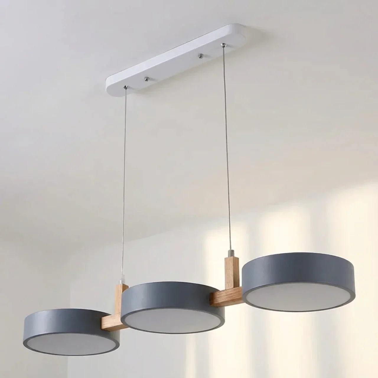 Suspension à poutre en bois avec abat-jours métalliques cylindriques pour îlot de cuisine
